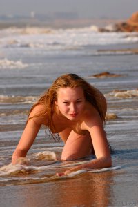 Молоденькая блондинка на морском берегу - фото ню