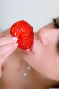 Красивая девушка ест клубнику - фото ню